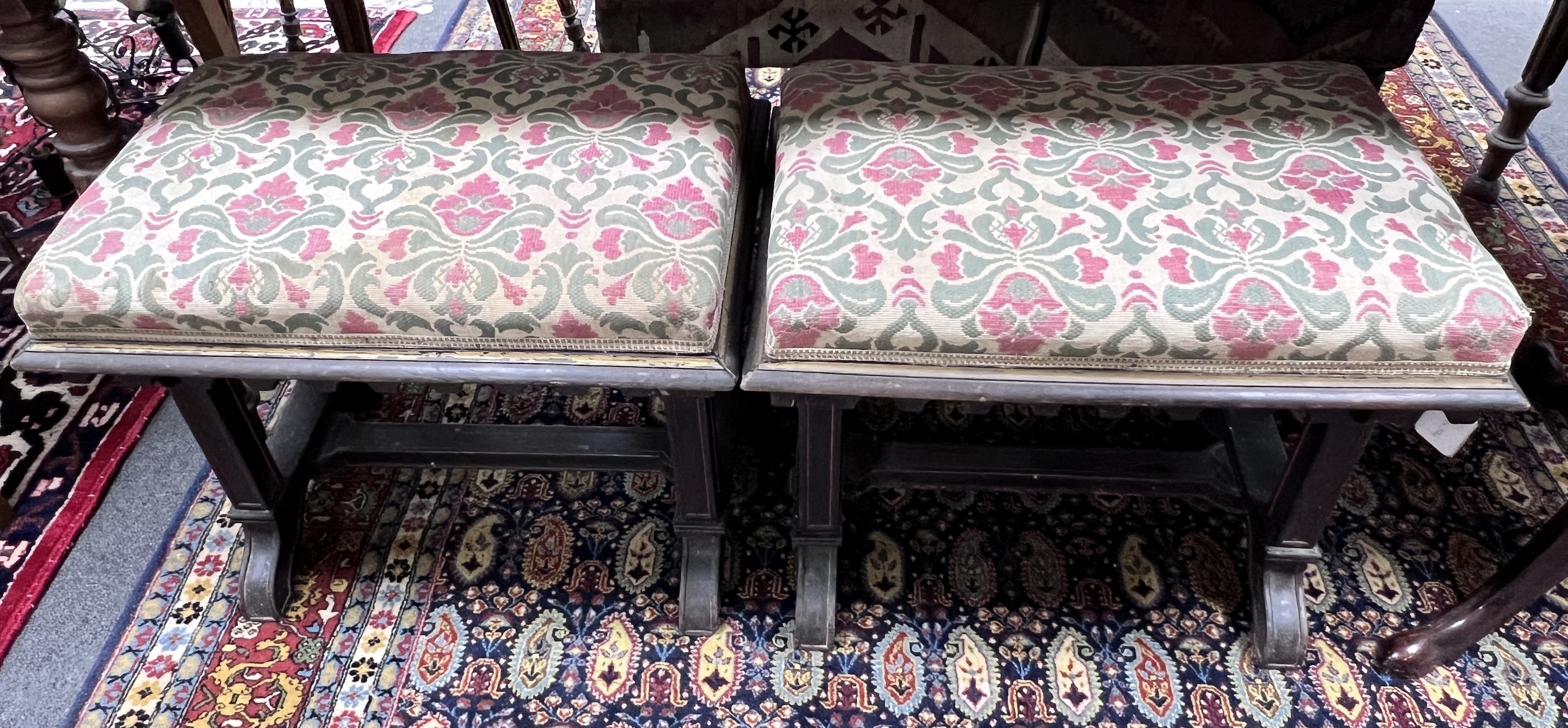 A pair of Victorian upholstered and ebonised stools of neo Gothic design, width 58cm, height 47cm